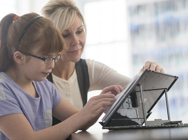 An adult and a child looking at a digital tablet together.