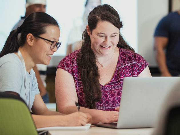 2 people working on a laptop together.