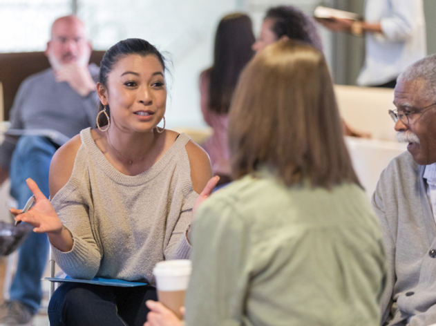 A person having a conversation with a group of people in an office.